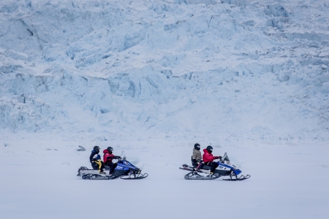 Snowmobile Along A Glacier Wall